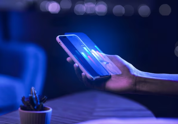 Pessoa segurando um smartphone com projeção holográfica tridimensional acima da tela.